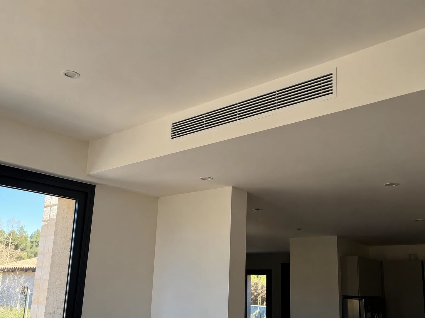 Grille de soufflage linéaire de climatisation gainable intégrée dans le faux plafond d’un séjour