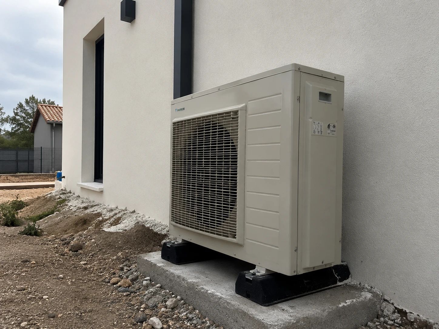 Groupe extérieur de pompe à chaleur air-air posé sur supports antivibratiles et dalle béton